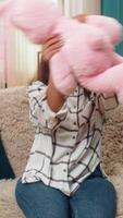 Indian woman at home holds pink bunny toy smiling nostalgic remembering childhood missing child. Arabian girl on sofa gazes at plush rabbit soft toy showing tender warm sentiment longing memory love. video