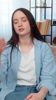 Young woman at home sitting on sofa upset and disappointed doing facepalm gesture, frustrated by her mistake. Caucasian girl demonstrating dissatisfaction, emotional regret and unhappy feelings. video