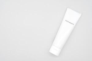 Minimal White Toothpaste Tube with Copy Space. White toothpaste tube with simple TOOTHPASTE text. dental care, oral hygiene, beauty, cosmetic products, health, and personal care branding. photo
