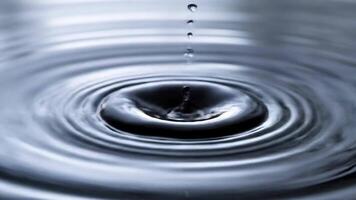 Droplets of water create ripples and abstract designs in a clean and elegant visual moment, illustrating liquid dynamics video