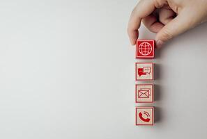 Wooden blocks with customer service icon with online contact options for contact us or service department to solve problems and answer questions. Communication network system concept. photo