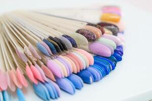 A row of nail polish bottles with a variety of colors photo