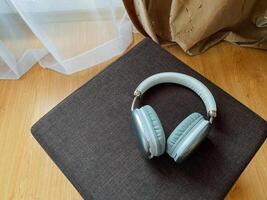 There is a pair of headphones gracefully resting on top of a plush brown cushion, showcasing its sleek design and functionality as an important electronic accessory for music lovers photo