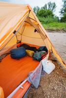 Within the spacious confines of the large tent, a considerable quantity of luggage is stacked high, resulting in a busy appearance filled with diverse and bustling outdoor gear and supplies photo