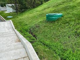 A picturesque lush green hill featuring a step pathway that guides visitors through the landscape, along with an access point for equipment, making it perfect for outdoor activities and exploration photo