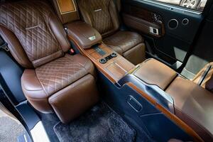 The luxurious leather interior of a highend vehicle is designed with attention to detail, featuring elegant wooden accents that enhance the aesthetic appeal and provide comfort to all passengers photo