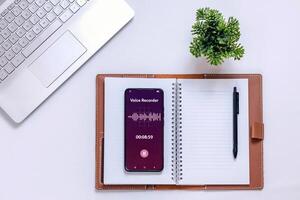 A smartphone recording sound during a meeting to take minutes. Audio recording for meeting notes concept. photo