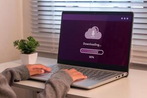 A young girl using laptop to download media or update software. Downloading process bar on laptop screen. photo