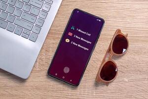 A smartphone on a desk with notification of missed call and new message on the phone screen photo