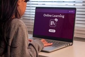 E-Learning, Online Education or Virtual Learning concept. A young girl studying online on a laptop. photo