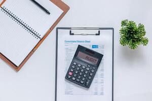 Notebook, pen, calculator, and financial data paperwork on desk. Financial audit concept. photo