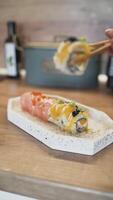 Close-Up of Hand Adding Final Ginger Garnish on Sushi Rolls in a Homemade Kitchen Setting video