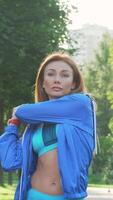 Graceful sportswoman preparing for an invigorating jog in a vibrant park video