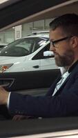 Sales manager engages with a customer inside a sleek vehicle, showcasing features video