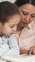 Asian mother and daughter sharing a joyful reading moment video