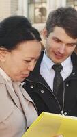 Cheerful man and woman engage in a lively discussion over documents video