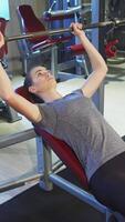 Determined girl lifting a heavy barbell in the gym video