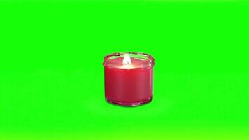 Close Up Red Candle Burning with Bright Glowing Flame on Green Background video