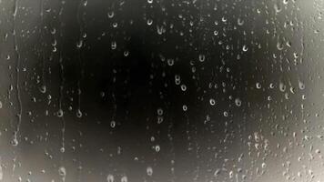 Water Droplets on Glass Surface with Dark Gray Background Creating an Atmospheric Weather Scene and Artistic Effect For Adobe Stock video