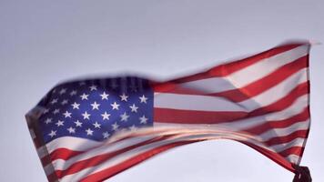 Independence Day American flag against the background of the blue sky blowing in the wind. close up video