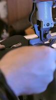 A person is sewing a piece of fabric on a machine video
