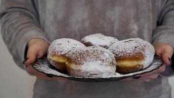 A person holding a plate with powdered doughnuts video