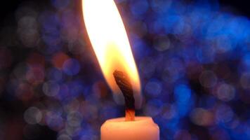 Illuminated Candle Flame Against Colorful Bokeh Background Creating Warm Ambiance video