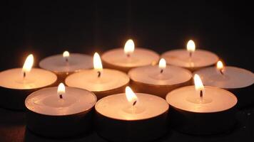 Eight tealight candles glowing warmly in the dark creating a calm and tranquil atmosphere perfect for reflection or celebration. video