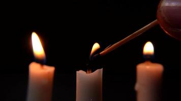 Candlelight Flames Ignited with Matchstick in Dark and Subdued Background. White candle flame video