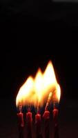 Four candles burning brightly in the dark. The small candle was blown out and lit again. Blow out the candles. Looping video