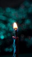 Vertical Shot of Lighting Candle with Match on Soft Blue Bokeh Background. Lighting birthday candles video