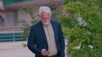 Senior businessman using smartphone near office building video