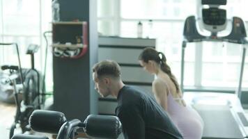 Man and woman doing fitness exercises in gym. Strength, endurance and training focus in modern fitness center 43 video