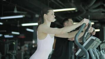 Man and woman doing fitness exercises in gym. Strength, endurance and training focus in modern fitness center 5 video