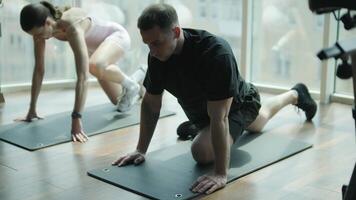 Man and woman doing fitness exercises in gym. Strength, endurance and training focus in modern fitness center 41 video