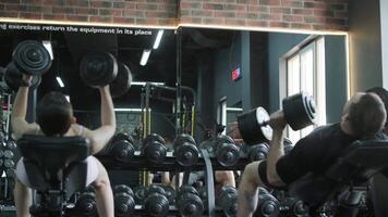 Man and woman doing fitness exercises in gym. Strength, endurance and training focus in modern fitness center 45 video
