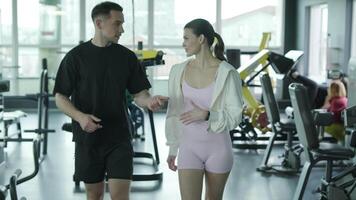 Man and woman doing fitness exercises in gym. Strength, endurance and training focus in modern fitness center 70 video