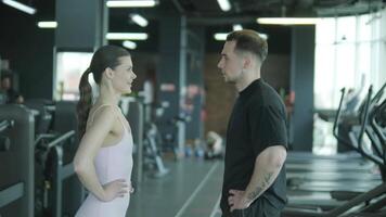 Man and woman doing fitness exercises in gym. Strength, endurance and training focus in modern fitness center 2 video