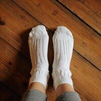 A person wearing white socks on a wooden floor photo