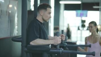 Man and woman doing fitness exercises in gym. Strength, endurance and training focus in modern fitness center 19 video