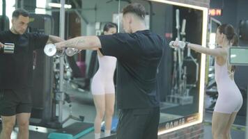 Man and woman doing fitness exercises in gym. Strength, endurance and training focus in modern fitness center 26 video