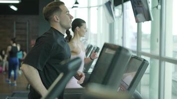 Man and woman doing fitness exercises in gym. Strength, endurance and training focus in modern fitness center 60 video