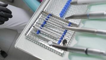 Preparation for the dental procedure. Surgery tools. Multiple surgery tools on the table in operating room. Scrub nurse hands in rubber gloves. Modern dental concept. video