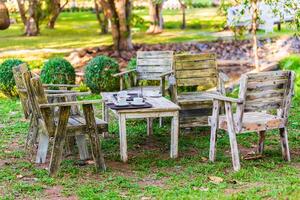 Wooden coffee table and chairs in garden at summer day. photo