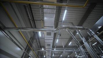 HVAC Duct Cleaning, Ventilation pipes in silver insulation material hanging from the ceiling inside new building. video