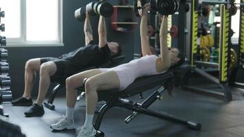 Man and woman doing fitness exercises in gym. Strength, endurance and training focus in modern fitness center 49 video