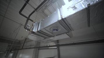 HVAC Duct Cleaning, Ventilation pipes in silver insulation material hanging from the ceiling inside new building. 4 video