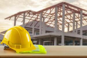 A hard hat and safety glasses on a table in front of a building photo