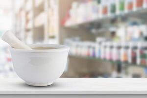 A white mortar and pestle sitting on a table in front of a pharmacy photo