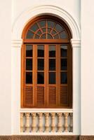 Classic Wooden Window with Shutters and Decorative Balcony Design photo